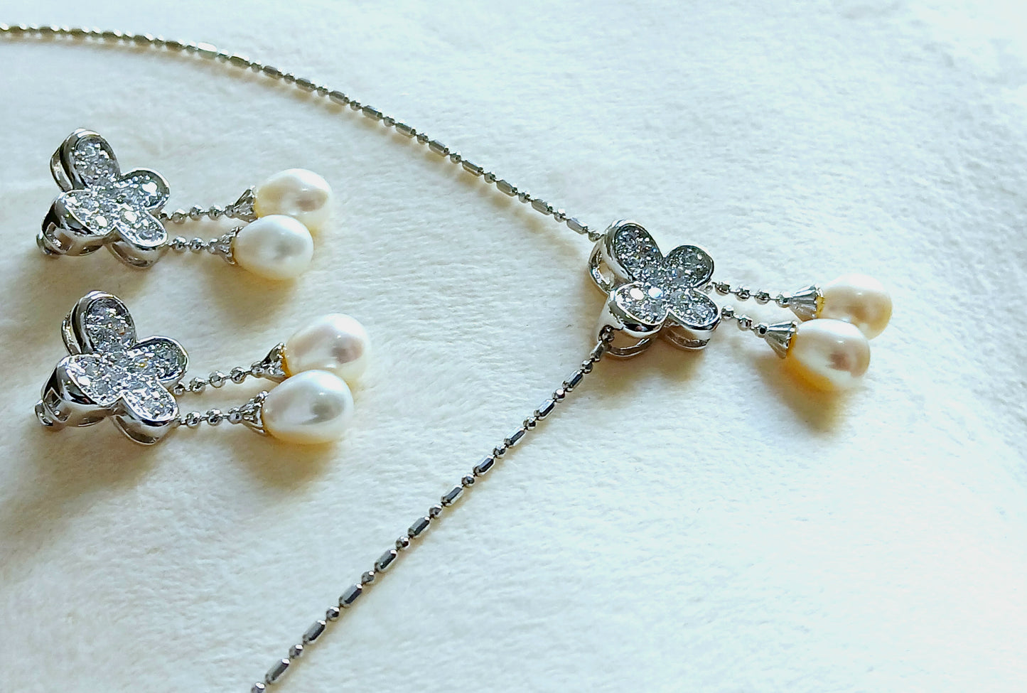 Dangling pearls and Cubic zirconia in 925 precious silver. Floral earrings and pendant set